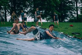 People, sliding on the water, among the green plants