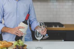 man with a bottle of wine in the kitchen