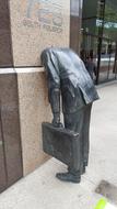 businessman with head at wall, sculpture at office building