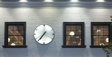 Wall with the clock with light, and windows, near the plant