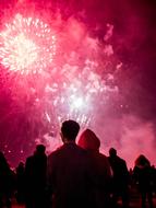 silhouettes of people on the background of fireworks at night