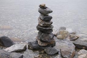 Close-up of the colorful, shiny beautiful tower of stones, among the water