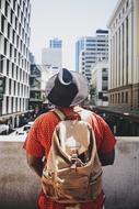 man with a backpack in the center of a modern city