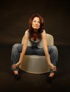 brunette posing on a round armchair