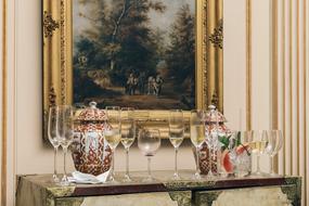 glasses of wine and vases on an antique dresser