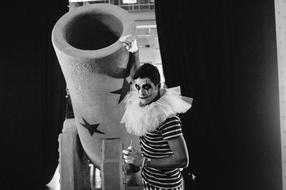 monochrome photo of a clown with a gun