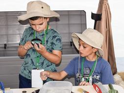 Little archaeologists in hats, at the table