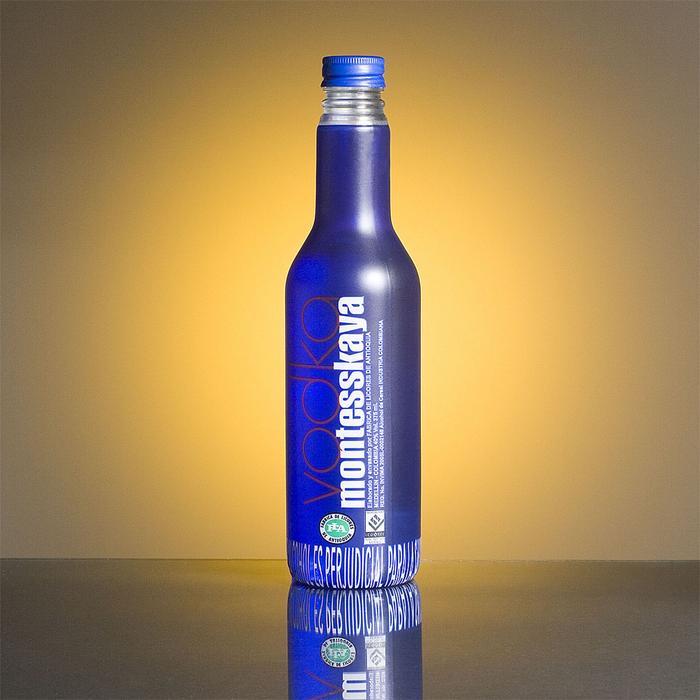 Blue liquor bottle with reflection, at background with light
