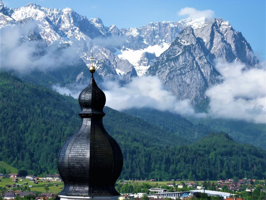 the black tower of the church against the background of the mountains