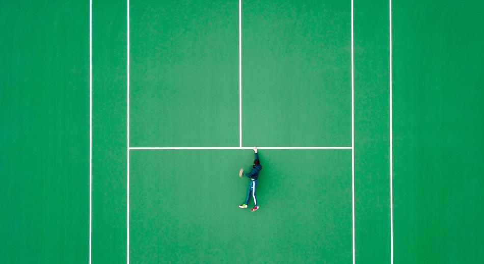 a young man lies on a tennis court