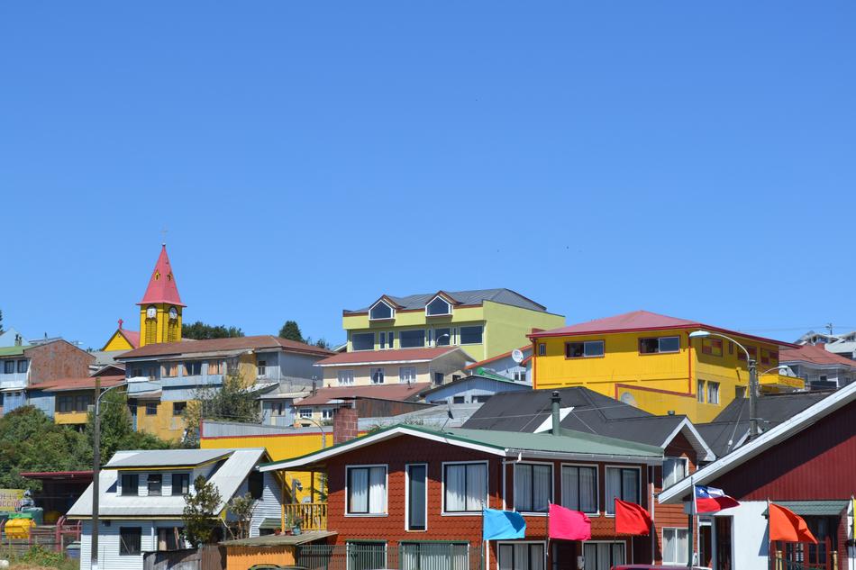 panorama of colorful buildings and flags on a blue sky background