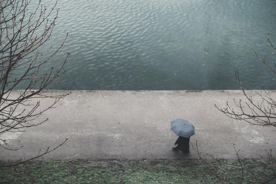 man under an umbrella near the water