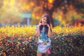 girl posing against the background of a blurry autumn landscape