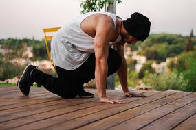 Itamar Kazir, doing street workout, on the wooden path, among the green plants