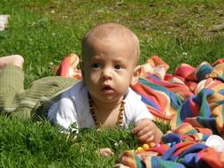 cute baby resting on the grass in the park