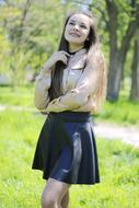 photo of a student in a blouse and leather skirt on the lawn