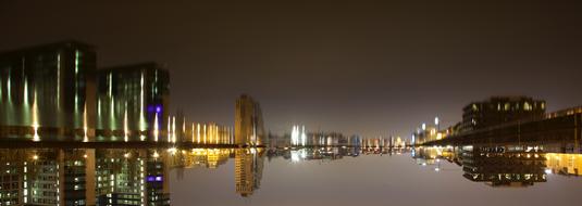 Water with reflections among the buildings, with colorful lights, in Berlin, Germany, at the night