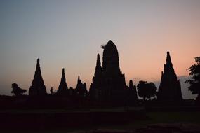 silhouettes of buddhist temples at pink blue sky