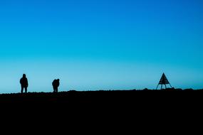 silhouettes of people on a rock