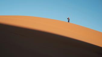 a man on a sandstone cliff in the desert