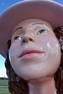 Portrait of the shiny sculpture of the girl, with the hat