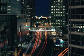 Cityscape with the colorful lights in movement, among the buildings, at the night