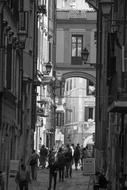 Beautiful, black and white photo of the street with people, among the buildings in Rome, Italy