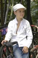 boy in white on a bicycle on a blurred background