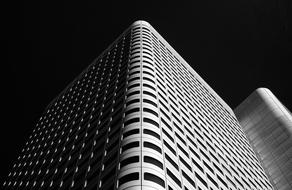 Black and white photo of the shiny buildings with windows, at black background, clipart