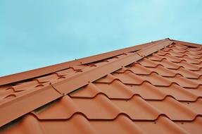 Close-up of the brown roof of the house, at blue sky on background