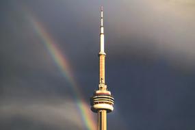 Tower at background with the dark sky with colorful rainbow