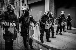 Police officers with transparent shields on street, Protest