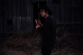 Boy in hat, with the book, outside