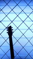 neck of the guitar on the background of the lattice