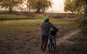 a man with a bicycle in a field