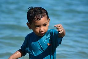 little boy playing near the water