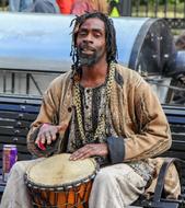 african young Musician plays drum on street