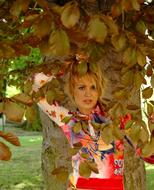 girl under the dense crowns of a large tree