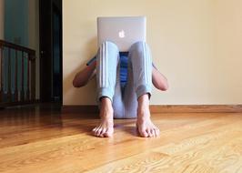 male Person sits at wall with laptop Computer