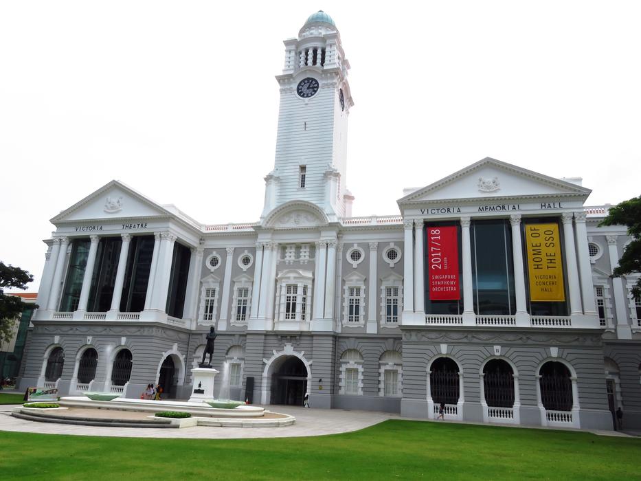 Building with colorful signs, and green grass, in Singapore
