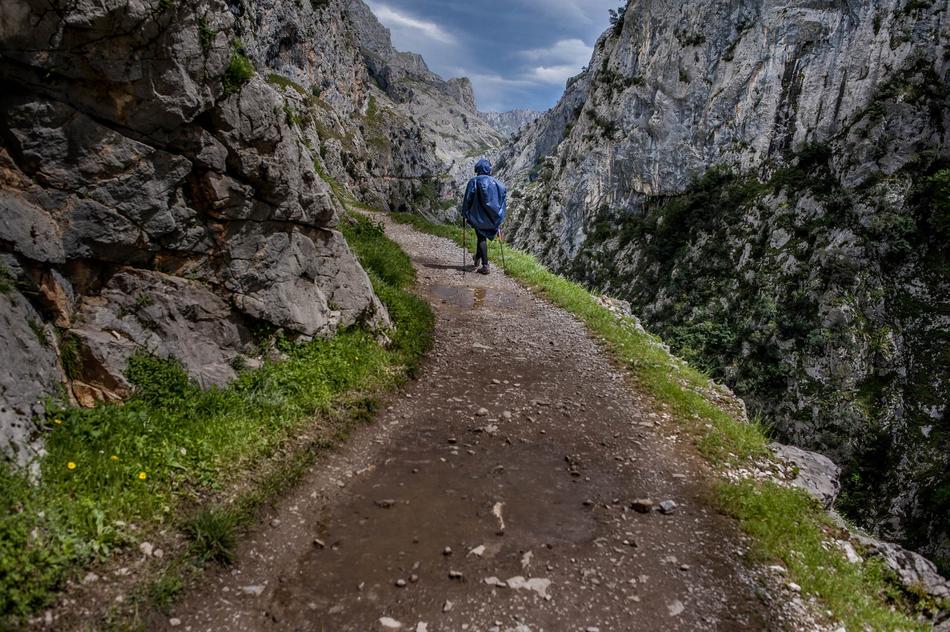 a man walking on the road in the mountains