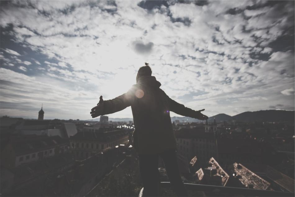 silhouette of a guy over the city in the sun