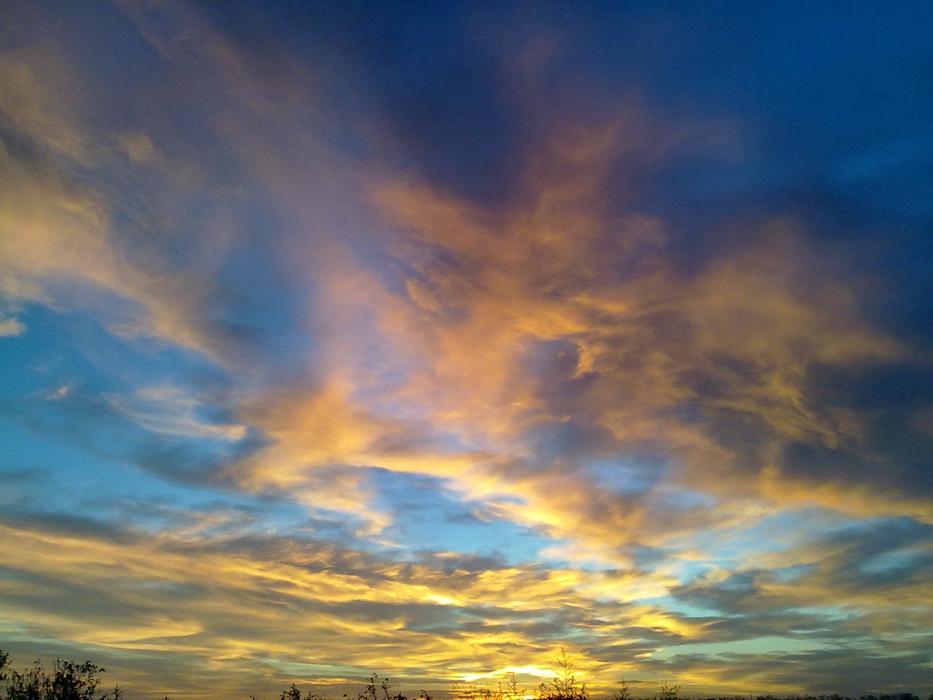 Beautiful and colorful sunrise in the sky with the clouds, above the seaside