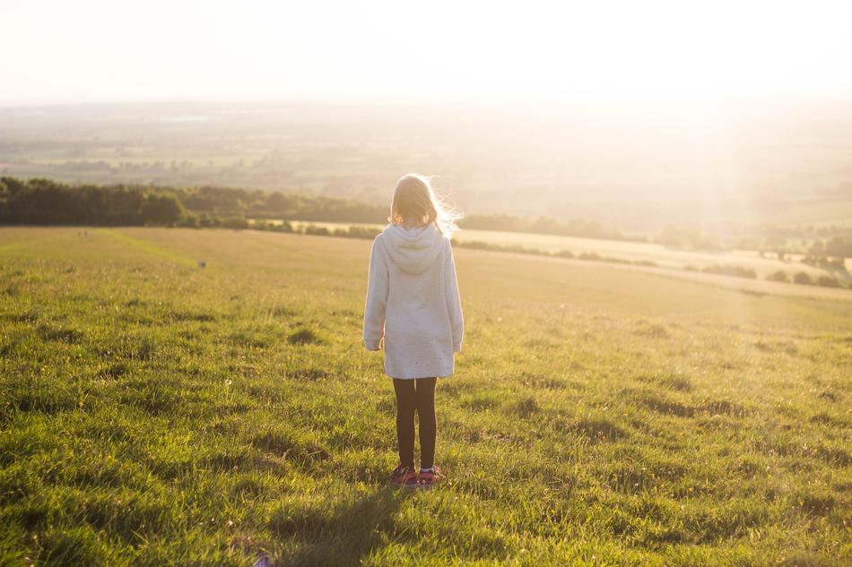 a girl in a white dress in a field