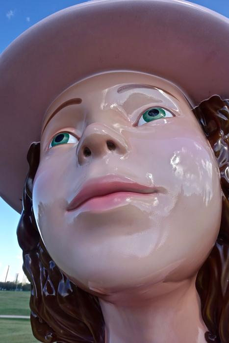 Portrait of the shiny sculpture of the girl, with the hat