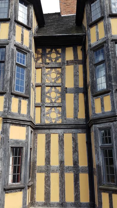 Beautiful, yellow and dark Tudor house with windows