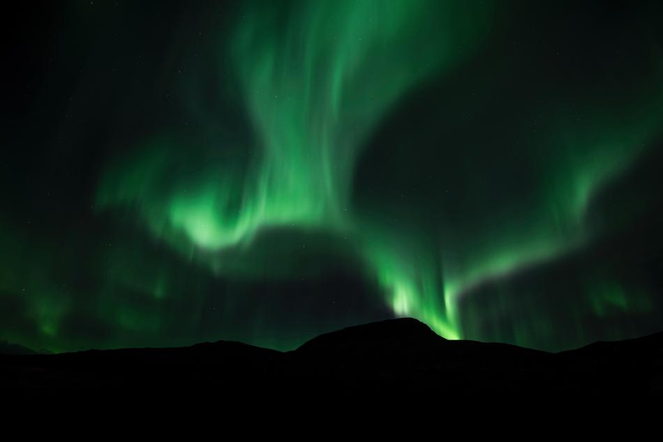 a beautiful green glow in the black sky.