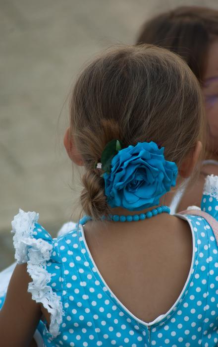 Andalusian girl in blue and white dress and with blue flower