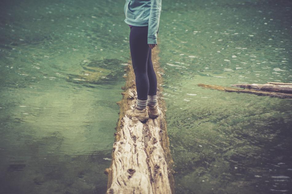 girl on a log on the lake