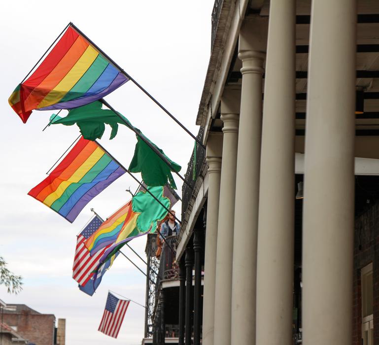 Colorful flags of LGBT and USA, on the building with columns, in USA